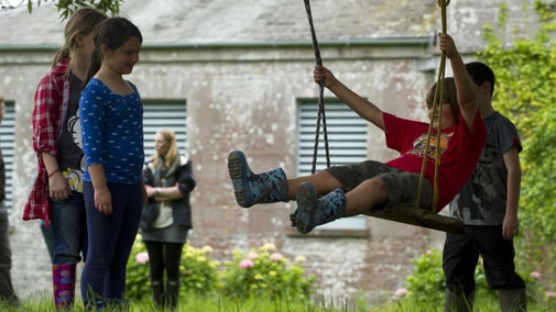 Children playing on a swing at Stackpole, Pembrokeshire.